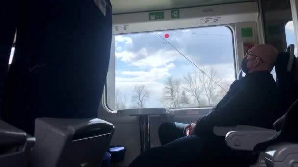 Seorang pria bertopeng melakukan perjalanan dengan kereta api untuk bekerja. — Stok Video