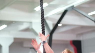 Kadın spor salonunda iple idman yapıyor.