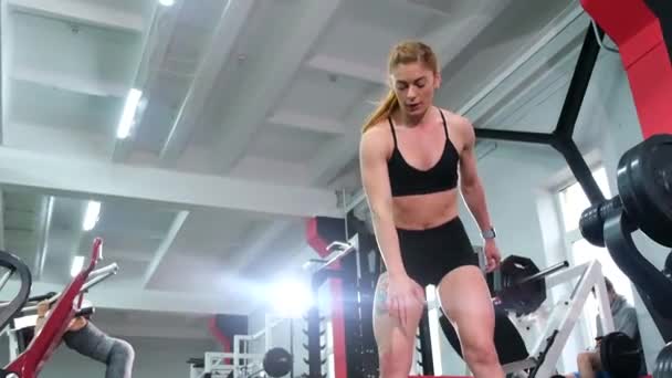 Fitness una atleta musculosa se entrena en el gimnasio con pesadas pesas — Vídeos de Stock