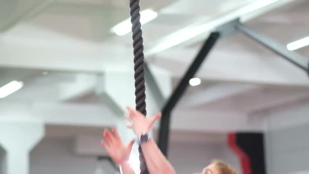 Mujer entrena en una cuerda en el gimnasio — Vídeos de Stock