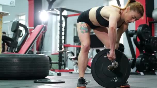 Fisiculturista realiza exercícios para levantar levantamento de peso em uma instalação de treinamento. — Vídeo de Stock