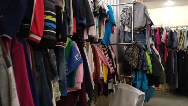 Veel kleren aan hangers in een tweedehands winkel — Stockvideo