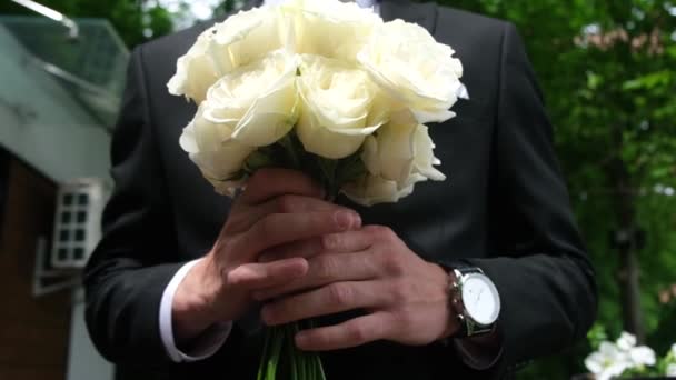 Svatební kytice nevěsty v rukou ženicha. — Stock video