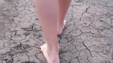 Çatlak toprak. Kurumuş bir gölün ya da nehrin dibinde yalınayak yürüyen bir kızın ayakları.