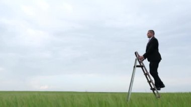 Siyah takım elbiseli bir adam kariyer merdivenine tırmanıyor. Kariyer merdiveni konseptinde iş adamı