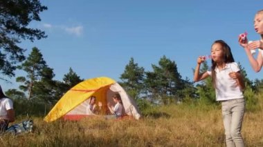 Bir grup mutlu çocuk çadır kampında dinleniyor..
