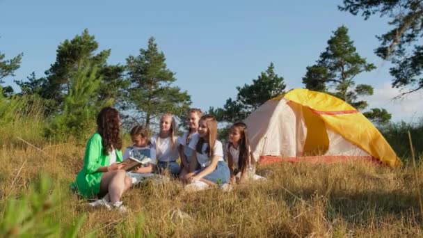 Jeune professeur avec des étudiants dans le camp en plein air sur la nature. — Video