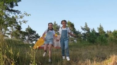 Bir yaz günü kamp alanının yanında koşan iki küçük kız.. 