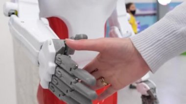  El sıkışın, yakın plan. Modern teknoloji ve bilim. Robotla insan tokalaşması. 