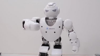 Modern robot teknolojileri. Beyaz robot bir dizi hareketini gösteriyor.