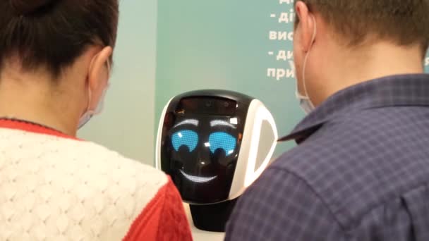 Robot avec affichage interactif communique avec les visiteurs dans un centre d'affaires. — Video