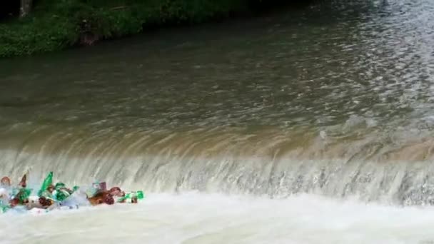 Large rivière sale avec de l'eau boueuse. Poubelles et pollution flottant dans l'eau. — Video