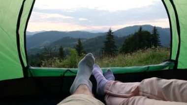 Çift yeşil bir çadırda dinlendi ve güzel dağlara baktı.. 