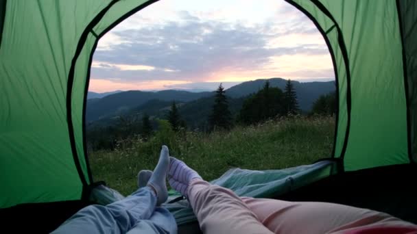 Jovem casal apaixonado sentado dentro de uma tenda verde no topo das montanhas canadenses. — Vídeo de Stock