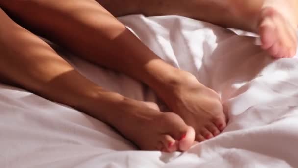 Молода пара в ліжку робить кохання. вид зверху їх ноги . — стокове відео