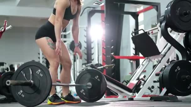 Женщина поднимает штангу в тренажерном зале, фитнес-женщина делает силовые упражнения. — стоковое видео