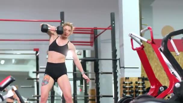 근육질의 여자 운동 선수가 무거운 초인종으로 체육관에서 훈련하는 모습. — 비디오