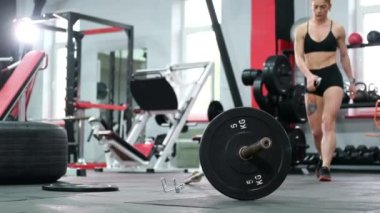 Spor salonunda ağır halterlerle antrenman yapan kaslı bir bayan sporcu..