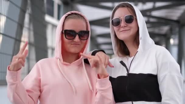 Two fashionably dressed girls dance in the middle of the street. — Stock Video