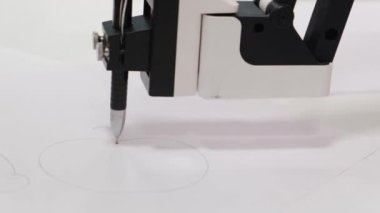 Programlanmış bir robotik beyaz manipülatör gelecekteki bir robot sergisinde kağıda çizim yapıyor..
