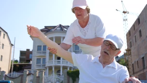 Rehabilitace starších lidí. Žena pomáhá nemocnému muži se sportem. — Stock video