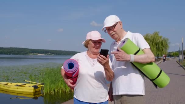 Äldres par använder en smartphone. Modern teknik för pensionärer. — Stockvideo