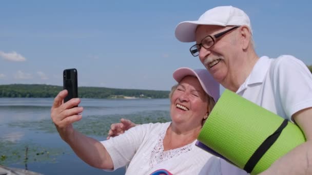 シニア退職カップル撮影自撮り写真上のスマートフォン. — ストック動画