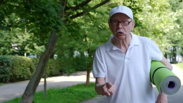 Le vieux grand-père parle avec colère à la caméra agitant son index. — Video