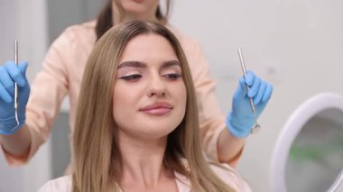 Bir kadın güzellik kliniğinde kozmetik bir işlem geçiriyor. Hem rahat hem de son derece mutlu görünüyor.