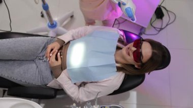 Hasta şu anda modern bir diş kliniğinde lazer teknolojisi kullanılarak diş beyazlatma tedavisi görüyor.