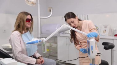 Kadın hasta, nitelikli bir dişçinin yakın gözetiminde diş tedavisi görmektedir..