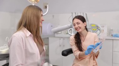 Arkadaş canlısı bir dişçinin, tedavinin detaylarını hastayla tartıştığı bir diş muayenesi..