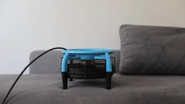 Zarif, şık, mavi bir yelpaze lüks gri bir koltuğa uzanmış modern yaşam alanlarının zarafetini arttırıyor.