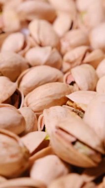 Doğal kabuklarındaki şam fıstıklarının detaylı bir yakın çekimi eşsiz şekillerini, dokularını ve canlı toprak tonlarını vurguluyor..