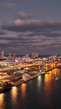 Alacakaranlıkta aydınlatılan Miami Limanı 'nın güzel manzarası gece gökyüzüne karşı parlayan gemileri, rıhtımı ve şehir siluetini gösteriyor..