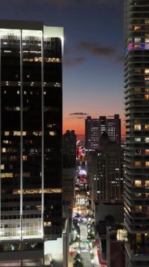 Gece vakti Miami şehir merkezindeki gökdelenlerin hava görüntüleri, parlak şehir ışıkları ve canlı gece hayatı ile aydınlatılmış büyük ve modern bir metropolü gösteriyor..