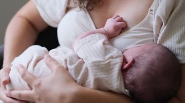 Genç bir annenin, yeni doğmuş bebeğini rahat bir evde emzirdiği hoş bir sahne. Samimi an şefkati, sıcaklığı ve erken anneliğin duygusal bağlantısını yansıtır..