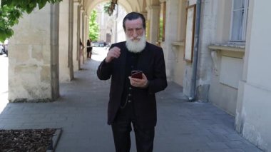 Yaşlı bir adam şehir merkezinde kısa bir mola veriyor, insanların ve arabaların geçişini izliyor. Sakin ve atmosferik sahne, yoğun bir şehir ortamında yaşlıları ve sakin yansımaları gösteriyor..