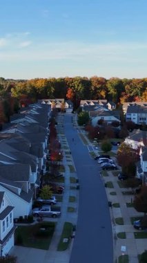 İnsansız hava aracı görüntüleri, Amerika 'da parlak turuncu ve sarı düşen ağaçlarla çevrili sessiz bir banliyö mahallesini gösteriyor..