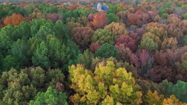 İnsansız hava aracı görüntüleri, uzak mesafede parlak sonbahar yapraklarıyla kaplı huzurlu bir orman ve küçük bir kilise olduğunu gösteriyor. Tipik Amerikan kırsal alanı sonbahar mevsiminde çekildi.