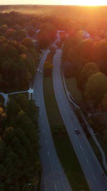 Hava görüntüleri, turuncu, sarı ve kırmızı gölgeli ağaç tepelerini gösteriyor. Yukarıdan bakıldığında sakin sonbahar manzarası.