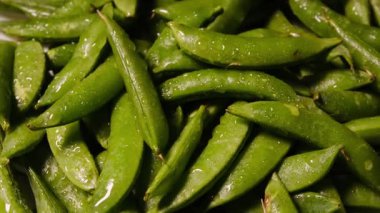 Canlı yeşil renkli ve detaylı dokuya sahip taze bezelyelerin yakın çekim makro görüntüleri. Sağlıklı yemek, vejetaryen yiyecekler, organik tarım ve beslenme kavramları için mükemmel..