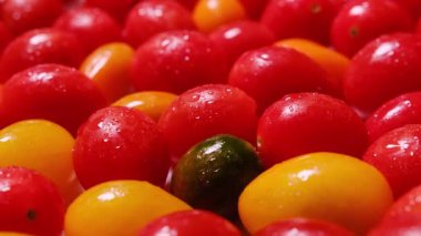 Kırmızı kiraz domateslerinin doğal dokusu ve yumuşak yansımalarının yakın çekim makro videosu. Sağlıklı yemek, tazelik ve vejetaryen diyeti konuları için mükemmel..