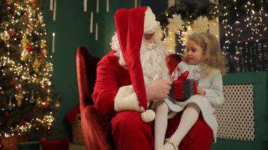 Noel kutlaması boyunca Noel Baba 'nın kucağında oturan çocuk.