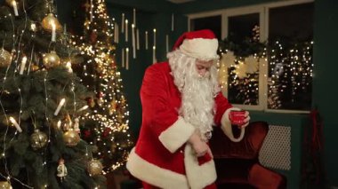 Noel Baba sakin bir şekilde parlayan bir Noel ağacının yanında duruyor, sakin ve huzurlu bir bayram anının tadını çıkarıyor..