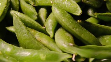 Doğal dokuyu, canlı yeşil rengi ve organik tazeliği vurgulayan kabuklu taze bezelyelerin makro görüntüleri..