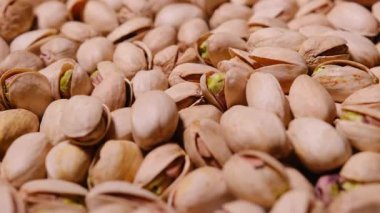 Antep fıstığının makro görüntüleri yavaş yavaş dönüyor, doğal dokuyu, detaylı kabukları ve organik bej rengi ortaya çıkarıyor..