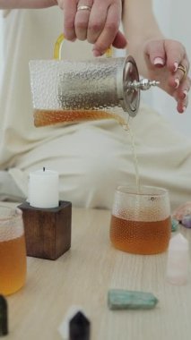 Ruhani iyileşme sırasında fincana bitki çayı dökmek sakin ve rahatlatıcı bir atmosfer yaratır. Dikey video