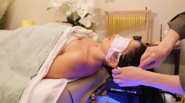 Bir spa terapisti, hastalarının saçlarını ılık suyla yıkar ve huzurlu bir saç bakımı sırasında yumuşak bir kafa masajı yapar..