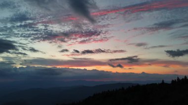 Pembe ve mavi akşam bulutları uzak bir dağ sırtı üzerinde uzanıyor ve ABD 'de canlı ve atmosferik bir alacakaranlık manzarası yaratıyor..
